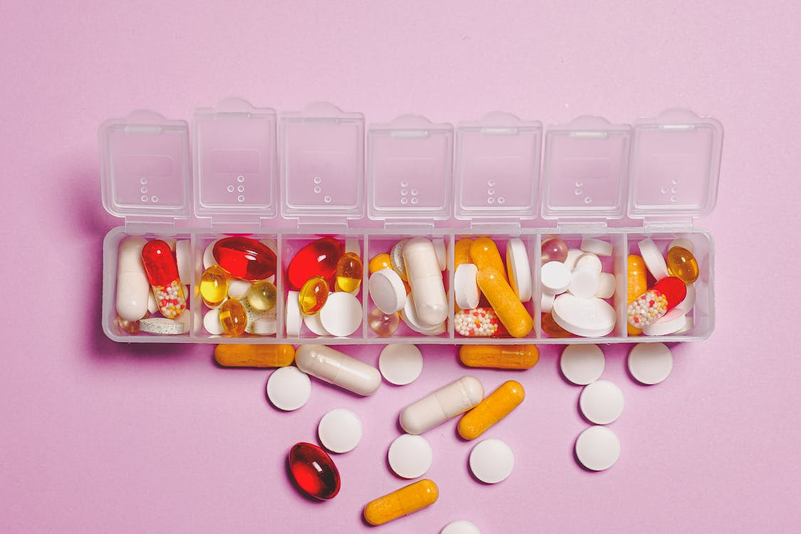 Prescriptions refilled in a clear plastic container with capsules